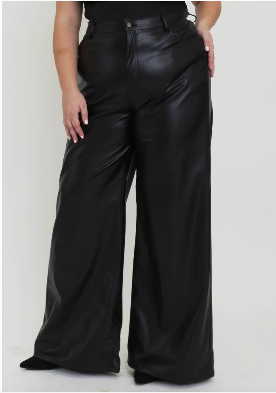 Plus sized woman wearing black coated pants.