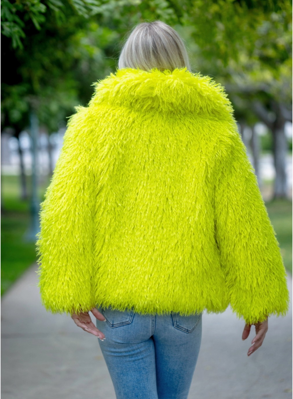 The back of a waist length bright yellow faux fur coat.