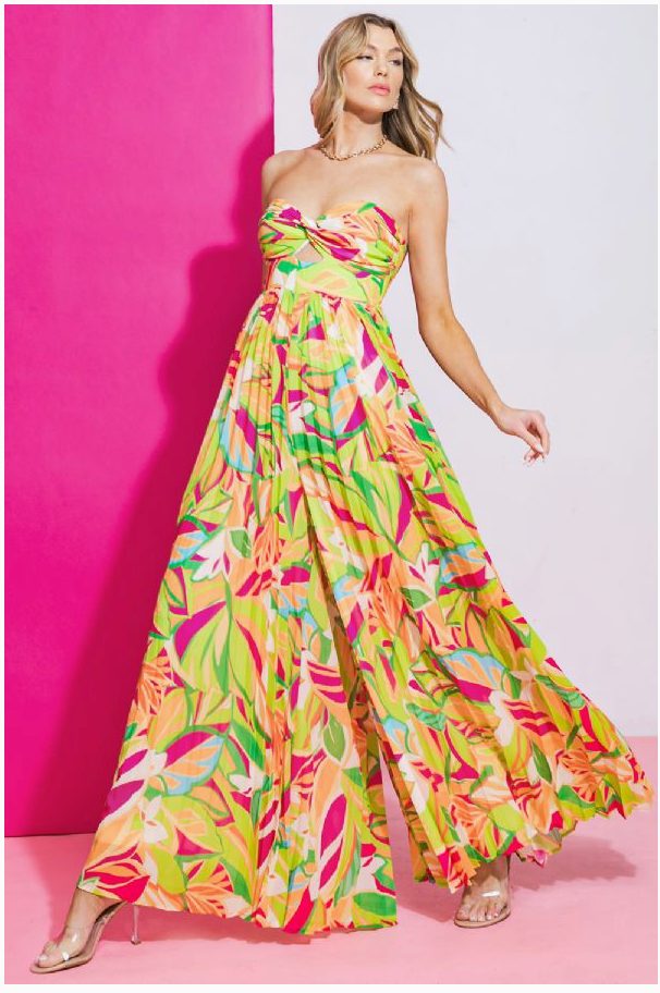 A woman wearing a multicolored jumpsuit with a sweetheart neckline and long, flowy, pleated pants.