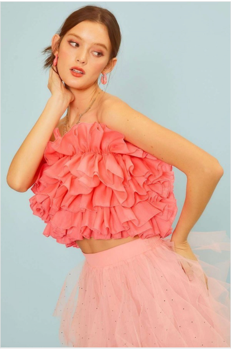 Woman wearing pink ruffle tube top.