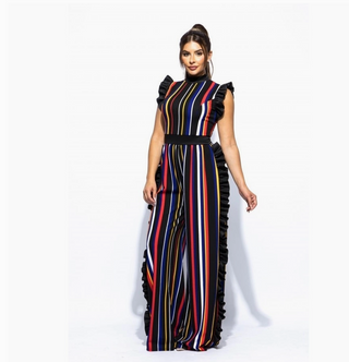A woman wearing a multicolored striped jumpsuit with ruffle accents and a cinched waist.