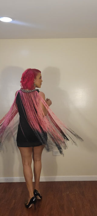 Woman wearing an ombre pink and black fringe dress with a silver rope chain.