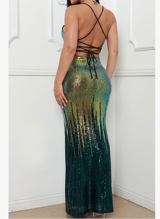 The back of a stunning ombre sequin green dress with a deep v-neckline and spaghetti straps, sparkling sequins cover the dress, transitioning from gold at the top to a darker green at the bottom. The back is strapless. 