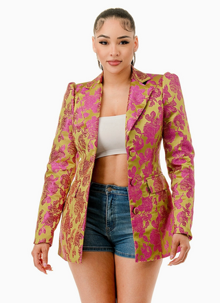 Woman wearing the Opulent Bloom Blazer, a luxurious floral brocade blazer in fuchsia and lime green. The blazer features a structured silhouette, notched lapel, and single-breasted button closure, creating a chic and sophisticated look.