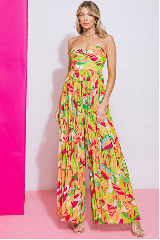 A woman wearing a multicolored jumpsuit with a sweetheart neckline and long, flowy, pleated pants.