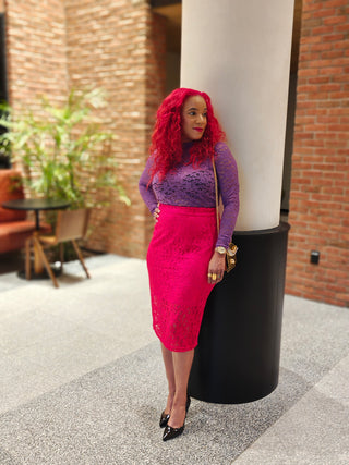 Woman wearing a red lace skirt with a lavender colored lace shirt. 
