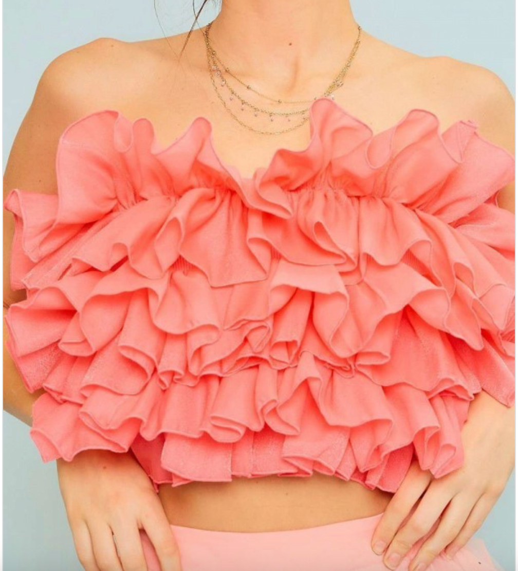 Woman wearing pink ruffle tube top. 