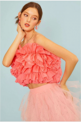 Woman wearing pink ruffle tube top.