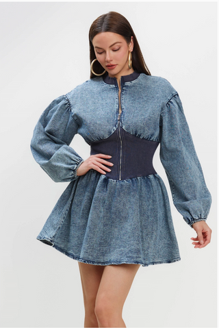 A woman wearing a Vintage Charm Denim Dress with a fitted waist, puff sleeves, and a zip-up front.