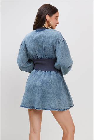 A woman wearing a Vintage Charm Denim Dress with a fitted waist, puff sleeves, and a zip-up front.