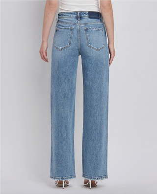 The back of a woman wearing a pair of vintage 90's style straight leg jeans with a high waist  and slight distressing on the hem.