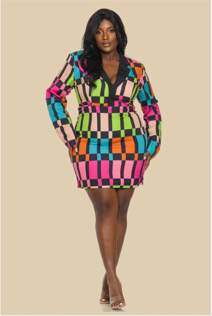 A woman wearing a plus sized multicolored geometric patterned dress with long sleeves and a V-neckline.